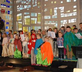 Eine flotte Kinderschar in Aktion vor dem eindrücklichen Kirchenfenster