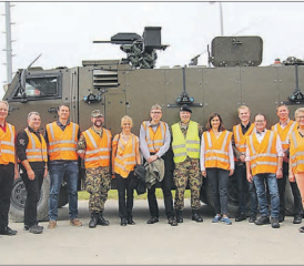 Zu Besuch auf dem Waffenplatz Bure beim «Stumpenbataillon»: Die Delegation der Sicherheitskommission des Kantons Aargau und ihre Gastgeber vor einem Geschützten Mannschaftstransportfahrzeug. (Bild: zVg.)