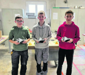 Einen Einblick ins Berufsfeld erhalten − drei der Schüler, die den Berufsinfotag der Paul Lüthi AG Schweiz besuchten, mit ihren Modellflugzeugen. (Bild: zVg.)