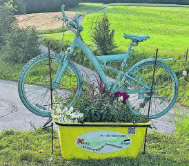 Originelle Werbebotschaften: Auf dem Böhler macht eine speziell geschmückte Mulde auf das Passstrassenfest aufmerksam; im Hintergrund das Festgelände. (Bild: wr.)