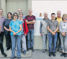 Die Wandergruppe bei der Erstbegehung des Barth-Thurneysen-Wegs: Vor der Tafel am Wöschhüsli neben der reformierten Kirche Uerkheim, neben der Tafel links die Gruppe von der Landeskirche und der Kirchgemeinde Safenwil mit Kirchenratspräsident Christoph Weber-Berg (li.) und Raffael Sommerhalder (hinten vor der Tür) und rechts die Gruppe aus der Kirchgemeinde Uerkheim. (Bild: zVg.)