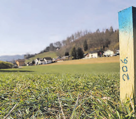 Die unterschiedlichen Farben der Bauprofile bezeichnen die Platzansprüche: Blaue Pfosten zeigen den Verlauf des Bachs an. Im Hintergrund das Gebiet Ostweg/ Eichenweg. (Bilder: Remo Conoci)