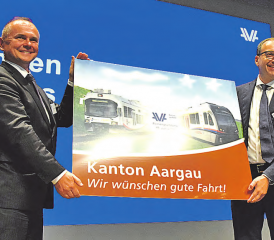 Freude über die Neugründung: Severin Rangosch, der Chef von «Aargau Verkehr» (links), und Verwaltungsratspräsident Kaspar Hemmeler freuen sich über das von Regierungsrat Stephan Attiger überreichte Bild zur Fusion von WSB und BDWM. (Bilder: zVg.)