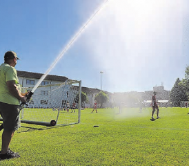 Unter dem kühlenden Nass konnte man auch bei grosser Hitze unbesorgt Fussball spielen. Uwe Essinger, Leiter der Jugendfeuerwehr Schöftland sorgte für Abkühlung.