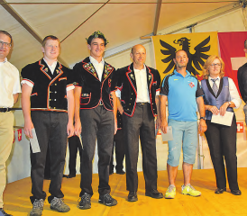 Roger Lehner (li.) und Uwe Mathiessen (re.) ehrten die Erfolgreichen: Auf der Bühne erschienen Delegierte des Jodlerclubs Echo und des Musikvereins Reitnau sowie des STV Reitnau. Pirmin und Adrian Reinhard zeigen sich, wie auch der Präsident der Jodler, Res Koller, in der traditionellen Tracht. (Bilder: st.)