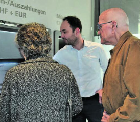 Kundenberatung vor Ort: Enrico Tiziani erklärt einem Ehepaar im Detail und mit Beispielen, was der neue Bancomat alles kann. (Bild: st.)