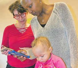 Die Leiterin der Mütter- und Väterberatung Susanne Breitenstein (li.) weist während eines Beratungstermins eine junge Mutter mit ihrem elf Monate alten Kind in die Nutzung der App «parentu» ein. (Bild: aw.)