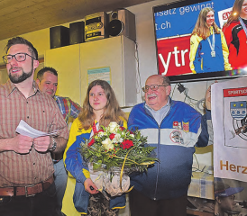 Sportliches Jubiläumsgeschenk: Präsident Daniel Berchtold (links) würdigte den Schweizer Juniorinnen-Meistertitel 10 m der Gewehrschützin Marion Obrist zu Beginn der Versammlung, rechts der langjährige Schulsportleiter Geri Künzli, hinten Schützenmeister Simon Hediger. (Bilder: wr)