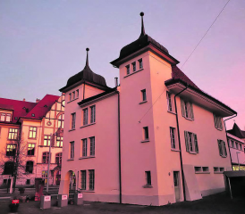 Der «Au Louvre» in der Abendstimmung der Altjahreswoche – Bei der rückwärtigen Ansicht sind die beiden Ecktürme gut erkennbar. Die Hauptstrasse kam 1877, das Schulhaus 1906.