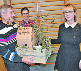 Hüttenwart für 26 Jahre Betreuung der Holziker Waldhütte geehrt: Lukas Treier (Bildmitte) überreichte Ueli Hunziker einen Geschenkkorb mit Miniaturwaldhütte, rechts Frau Gemeindeammann Jacqueline Hausmann. (Bild: aw.)