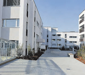 Das Leben geniessen an zentraler Lage mitten «Im Dorf»: Die Wohnungen bieten jeden Komfort. Die Umgebung wurde mit einheimischen Bäumen und Hecken gestaltet. (Bild: zVg.)