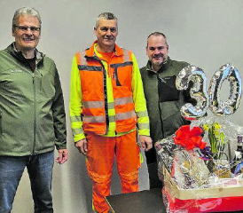 Jubilar Max Haller (Mitte) erhielt vom Staffelbacher Vizeammann Stefan Morgenthaler (links) und tbos-Betriebsleiter Nils Hunziker einen Präsentkorb. (Bild: zVg.)