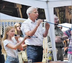 Gemütliches Beisammensein im Zetzwiler Werkhof Buholz bei Speis und Trank, bei Spiel und musikalischer Unterhaltung. Im Bild links Festredner Jürg Neuenschwander beim Blasrohrschiessen. (Bilder: zVg.)