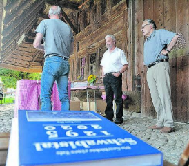 Beim Strohdachhaus in Muhen wurde das Buch von Kurt Rey (Mitte) präsentiert. Links von ihm hält Gemeinderat Hanspeter Brunner eine kurze Begrüssungsrede, rechts vom Autor wartet Historiker Pirmin Meier darauf, seine Laudatio zu halten. (Bild: Kaspar Flückiger)
