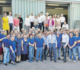 Gruppenfoto der Fretz Men AG: Hinten: Familienaktionäre,Angehörige und Verwaltungsräte der Fretz Men AG.Vorne: Jürg Schärer umgeben von der Belegschaft und der Geschäftsleitung mit den Herren Daniel Omlin (re.) und Walter Valenti (li.). (Bild: zVg.)