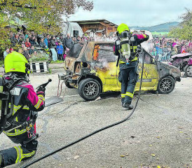 Das brennende Auto wird von der Feuerwehr Reitnau gelöscht. (Bild: kf.)