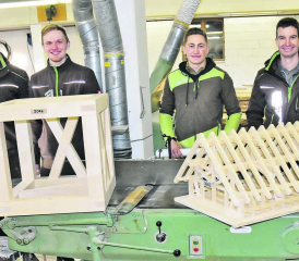 Zwei Lehrlinge im zweiten und dritten Lehrjahr präsentieren ihre prämierten Arbeiten: Lukas Hochuli einen Strebenwürfel, Janis Bossard einen Dachstuhl, Lehrlingsbetreuer Stefan Hofmann (l.) und Geschäftsführer Martin Hochuli (r.). (Bild: aw.)