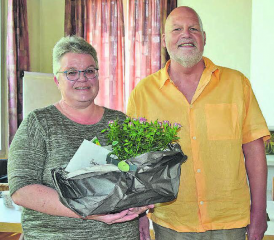 Seit 15 Jahren Kirchengutsverwalterin: Susanne Bircher erhält vom Präsidenten der Kirchenpflege, Beat Gautschi, rosarote Rosen und ein inhaltsschweres Kuvert. (Bild: st.)
