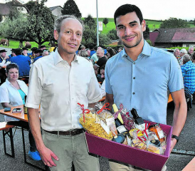Einen Korb mit Köstlichkeiten aus der Region erhalten: Gemeindeammann Patric Jakob und Festredner Benjamin Rodriguez (r.). (Bild: aw.)