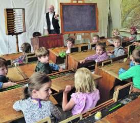 Ein Schulzimmer, wie es die Urgrosseltern erlebten: «Schulmeister» Hannes Gasser fragt die zweite Klasse nach den Unterschieden zur heutigen Ausstattung. (Bilder aw.)