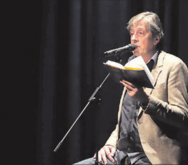 Auf grosser Bühne vor kleinen Tischchen und einem interessierten Publikum: Pedro Lenz las im Saalbau Reinach aus seinem Buch «Primitivo». (Bild: zVg.)