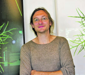 Abstraktes Wurzelwerk in schwarzem und weissem Hintergrund? Künstler Olivier Lorenz Schmid vor den beiden Fotos im Foyer des Schulzentrums Schöftland. (Bild: aw.)