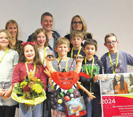 Freuen sich über den Preis des Kantons Aargau: (Erwachsene v.l.) Aline Bolliger und Alexandra Huber (Schule Schlossrued), Christa Schmid-Meier (BKS AG). Vorne: Schülerinnen und Schüler der Schule Schlossrued mit dem Schulmaskottchen Rucky Rued. (Bild: zVg.)