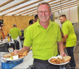 Noch nie einen falschen Ton gespielt: Fähnrich Bruno Bertschi schwingt für einmal die Teller mit frittierten Zanderfilets. (Bild: aw.)
