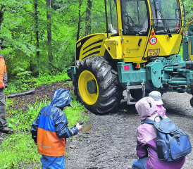 Kinder spielen im Schlamm: Für den Forstspezialschlepper interessierten sie sich vorerst nicht, links Maschinist Simon Engel. (Bilder: aw.)