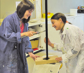 Wir dürfen uns nicht bekleckern: Zwei Mädchen sind offensichtlich bestens gelaunt an der Arbeit, Sorgfalt und Genauigkeit sind gefragt.