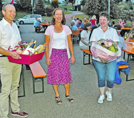 Genug Abstand: Patric Jacob und Gemeinderätin Stephanie Weber-Gloor überreichen Festrednerin und Krimiautorin Ina Haller (Mitte) einen Blumenstrauss und einen Korb mit Spezialitäten aus der Region. (Bilder: aw.)