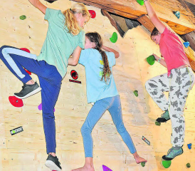 Mit starker Mädchenbeteiligung unterm Estrich des Gemeindehauses der reformierten Kirche: Pfarrer Beat Müller machte vor, wie Bouldern geht, danach probierten es Leana Zürcher,Aylin Huber und Lena Aeby (v. l.) ebenfalls an der Wand. (Bilder: aw.)