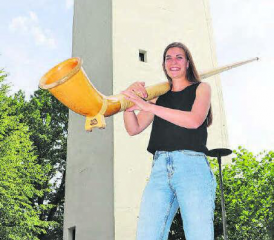 Lisa Stoll auf dem Kirchenplatz im Muhen. Im Nu ist das Alphorn ausgepackt und zusammengesteckt. (Bild: rc.)