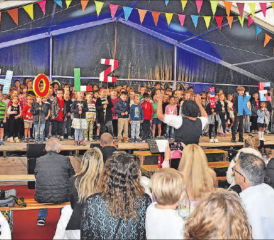 Die Showstars auf der Bühne: Schulkinder formen den Schriftzug «HOLZIKEN» und singen in Mundart zu «Blowing In The Wind». (Bilder: aw.)