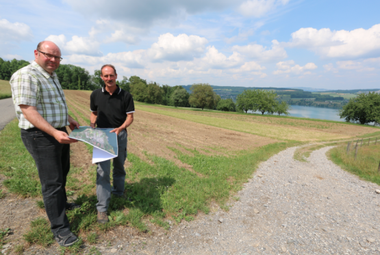 Martin (links) und Max Härri vor einem Feld in der «Widmi», das in sechs schmale Parzellen aufgeteilt ist. Ebenso sind jene sechs Eigentümer für den Unterhalt des Feldweges zuständig – das soll durch die Melioration vereinfacht werden. (Bild: Remo Conoci)