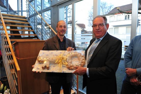 Der scheidende Böjuer Ammann, Johannes Eichenberger, überreicht seinem Nachfolger, Peter Lenzin, einen gebackenen Schlüssel.