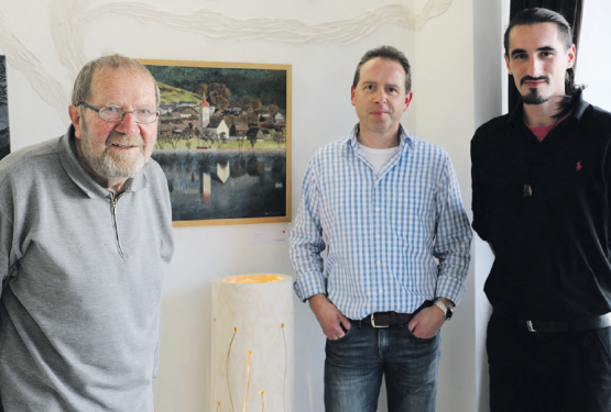 Drei Kunstschaffende, drei Quereinsteiger: Peter Huggenberger, Josef Häfliger und Gezim «Jimmy» Ristemi stehen vor zwei Werken der Ausstellenden. (Bild: rc.)