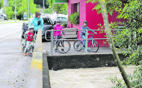 Anschauungsunterricht: Familie Bartholet aus Schöftland schaute sich das Hochwasser an der Holzikerstrasse aus nächster Nähe an. (Bilder: rc.)