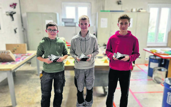 Einen Einblick ins Berufsfeld erhalten − drei der Schüler, die den Berufsinfotag der Paul Lüthi AG Schweiz besuchten, mit ihren Modellflugzeugen. (Bild: zVg.)