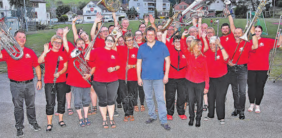 Nahmen den Dorfpfarrer in ihre Mitte: David Scherler in lockerem Outfit mitten unter der Uerkner Musikgesellschaft. (Bild: aw.)