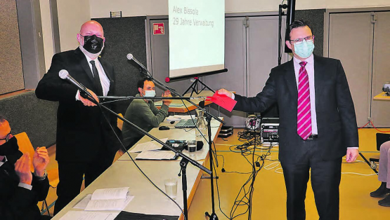 Abschied nach 29 Jahren: Alex Bissola (r.) erhält vom Gemeindeammann Erich Hunziker ein Abschiedsgeschenk aus sicherer Distanz. (Bild: Peter Weingartner)