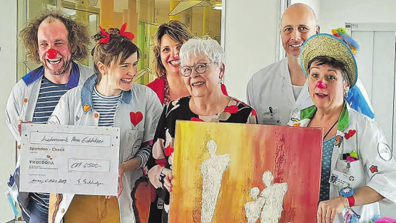 Scheckübergabe und Bildschenkung an die Stiftung Theodora im Kantonsspital Aarau: Erika Eichholzer spendete die Hälfte des Erlöses aus dem Verkauf der Bilder ihres verstorbenen Mannes. (Bild: aw.)