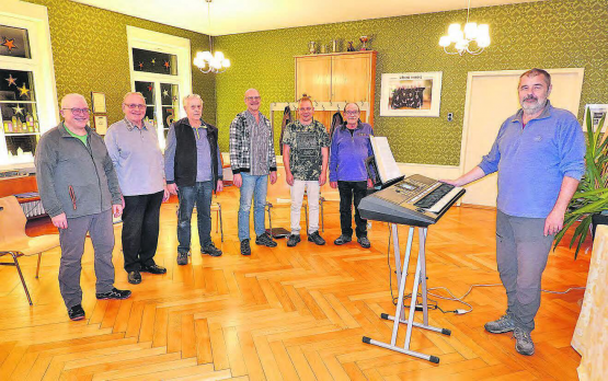 Der Männerchor Burg mit Dirigent Lubomir Rachunek ganz rechts: Die gesellige (wegen Abwesenheiten aber nicht ganz komplette) Runde, gönnt sich in der Singpause auch mal ein Gläschen Wein.