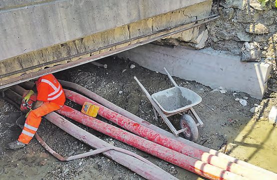Im Hintergrund das neu erstellte Brückenfundament: Das Bachbett ist auf der ganzen Breite trockengelegt, das Wasser wird mit Hochleistungspumpen und Schläuchen durch den Bereich der Baustelle geführt. (Bild: zVg.)