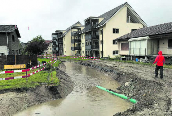Der Talbach im engen Siedlungsgebiet: Links ein kleines Hochwasser während der Bauarbeiten im Juni 2020 − und wie sich der Lauf des Talbaches im Jahr 2024 präsentiert. (Bilder: Sebastian Hackl/Remo Conoci)
