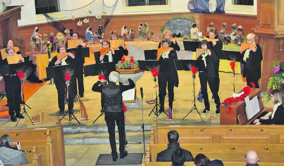 Mit der Weihnachtskrippe im Hintergrund: Die beiden Chöre formierten sich zu einer stattlichen Einheit unter der Leitung von Isidor Karf. (Bilder: st.)