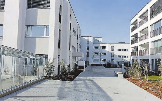 Das Leben geniessen an zentraler Lage mitten «Im Dorf»: Die Wohnungen bieten jeden Komfort. Die Umgebung wurde mit einheimischen Bäumen und Hecken gestaltet. (Bild: zVg.)