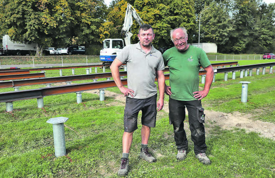 Jarek Kuzniar (l.) und Reto Zemp drehten mit dem Bagger im Hintergrund 176 Schrauben in den Boden, als Fundament für das Schulraumprovisorium in der Fluckmatt. (Bild: rc.)
