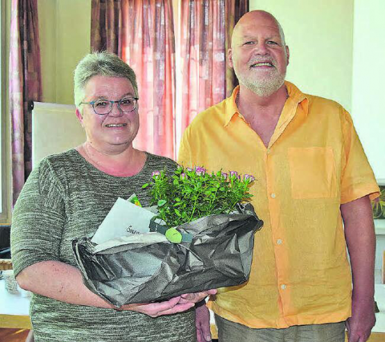 Seit 15 Jahren Kirchengutsverwalterin: Susanne Bircher erhält vom Präsidenten der Kirchenpflege, Beat Gautschi, rosarote Rosen und ein inhaltsschweres Kuvert. (Bild: st.)