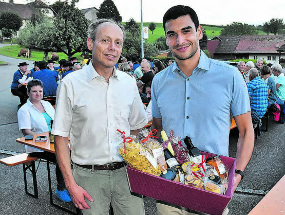 Einen Korb mit Köstlichkeiten aus der Region erhalten: Gemeindeammann Patric Jakob und Festredner Benjamin Rodriguez (r.). (Bild: aw.)